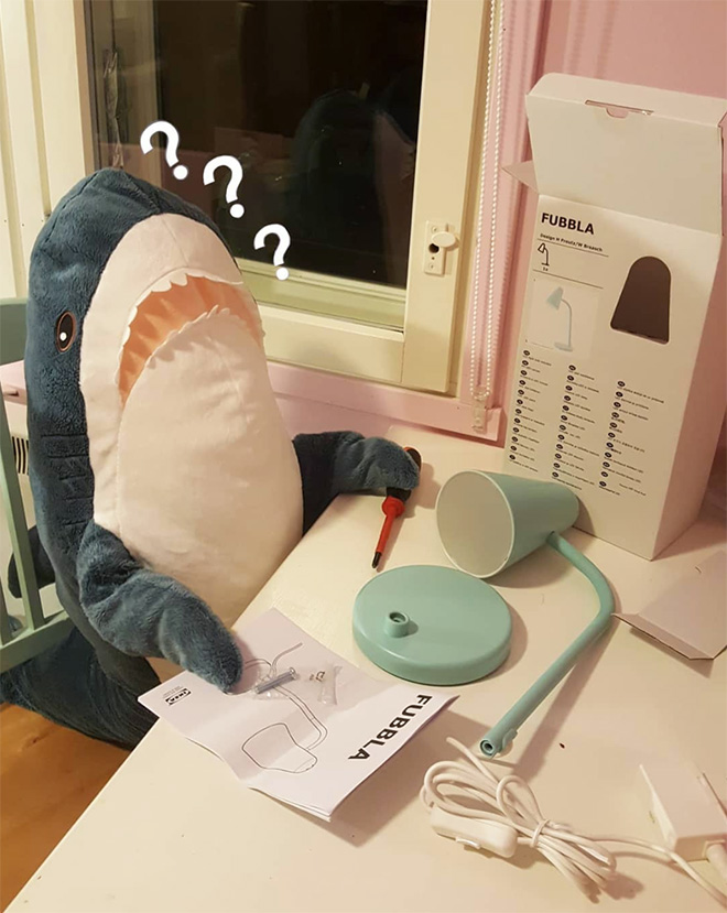 IKEA shark putting together IKEA lamp.