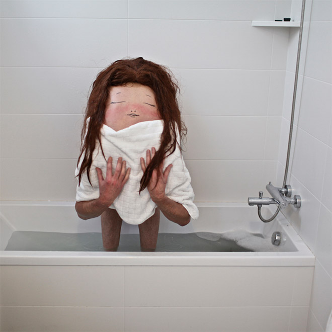 Creepy body art creature standing in a bath tub.