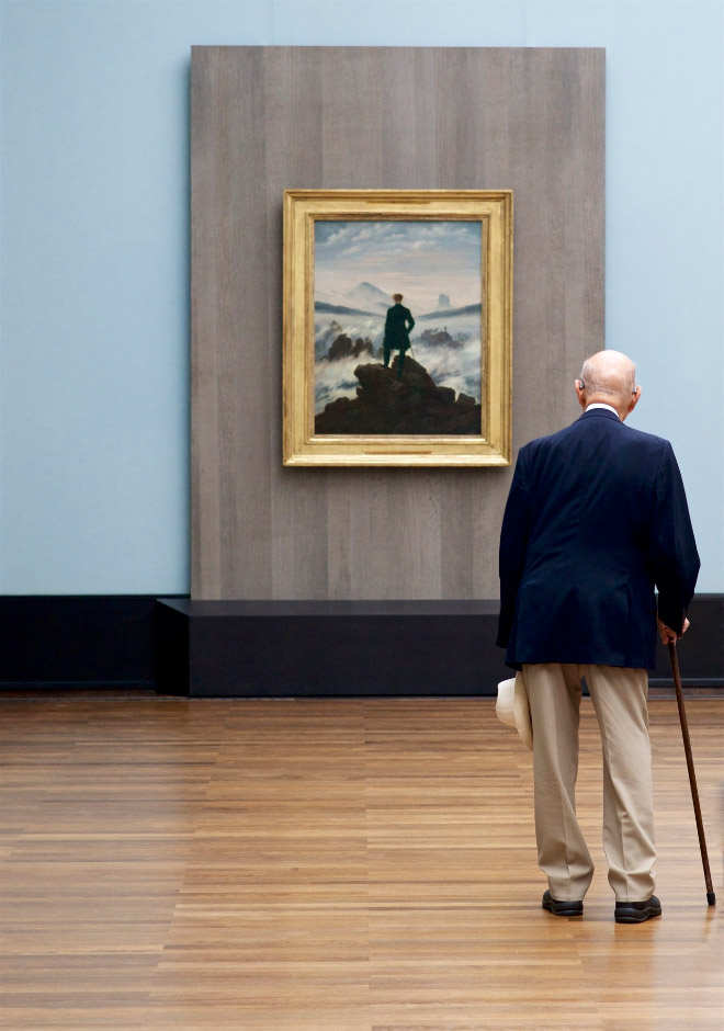 Old man perfectly matching a painting in an art museum.