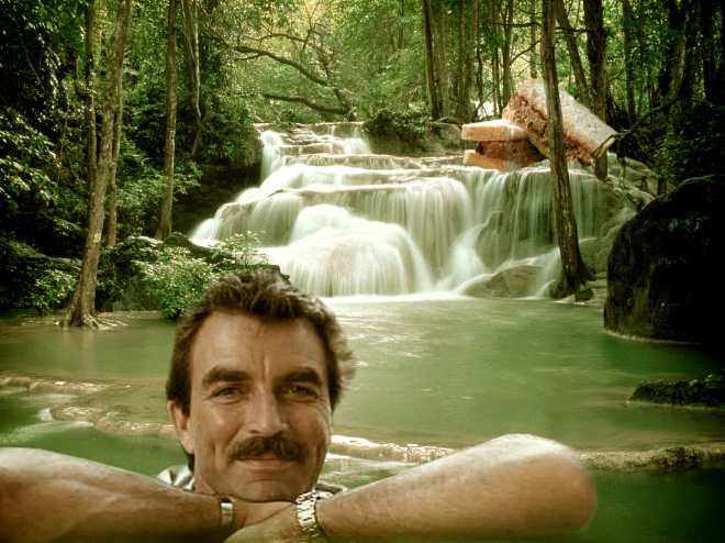 Tom Selleck hanging out with a sandwich in a waterfall.