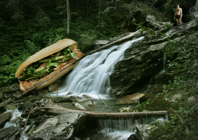 Tom Selleck hanging out with a sandwich in a waterfall.