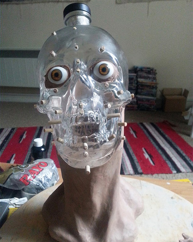 Facial reconstruction of a skull-shaped vodka bottle.