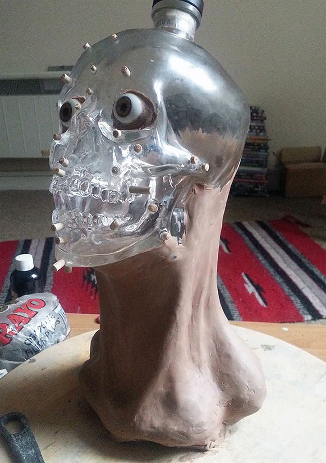 Facial reconstruction of a skull-shaped vodka bottle.