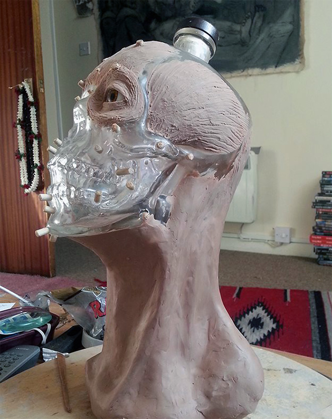 Facial reconstruction of a skull-shaped vodka bottle.