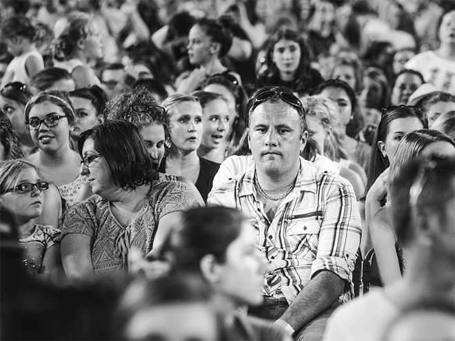 Dad suffering in a concert his daughter likes.