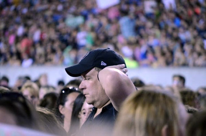 Dad suffering in a concert his daughter likes.