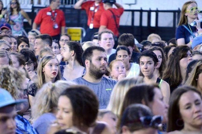 Dad suffering in a concert his daughter likes.