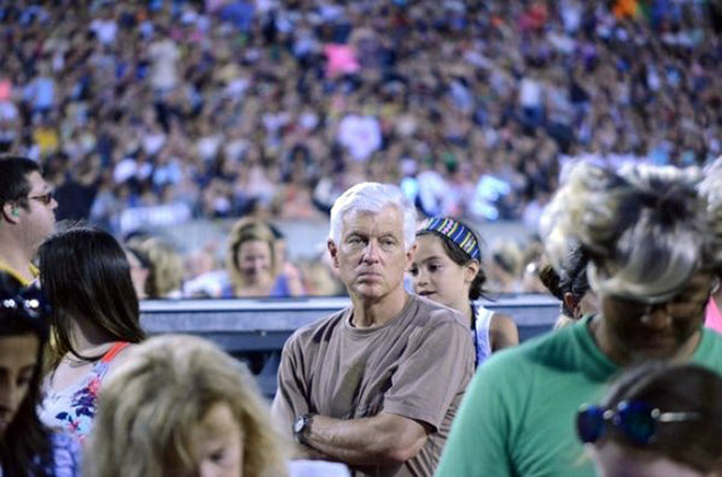 Dad suffering in a concert his daughter likes.