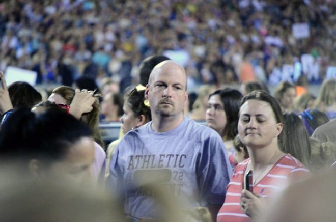 Dad suffering in a concert his daughter likes.