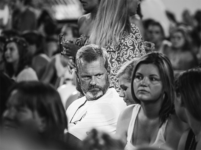 Dad suffering in a concert his daughter likes.